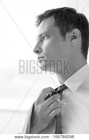 Close-up of pensive businessman loosening necktie in hotel