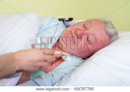 Picture of a bedridden elderly man having high temperature
