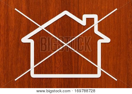 Strikethrough paper house on wooden background. Abstract conceptual image
