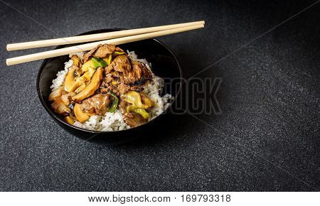 Chinese rice with beef meat and vegetagles on dark background