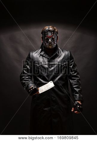 Bloody murderer in hockey mask with meat cleaver