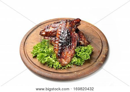 roasted turkey wings garnished with fresh green salad on the plate on white background