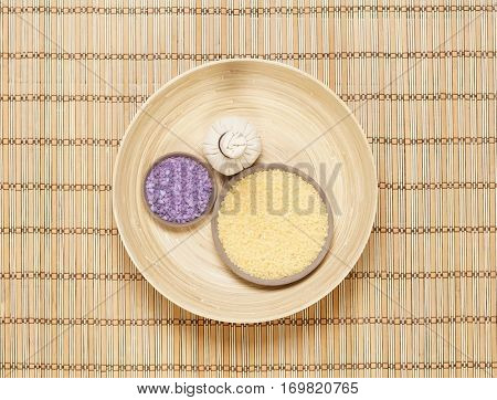Massage bundle on a plate with bath salt over bamboo mat. Spa, health, treatment concept.