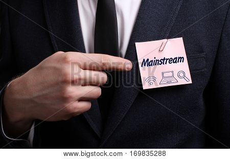 Business, Technology, Internet And Network Concept. Young Businessman Shows The Word: Mainstream