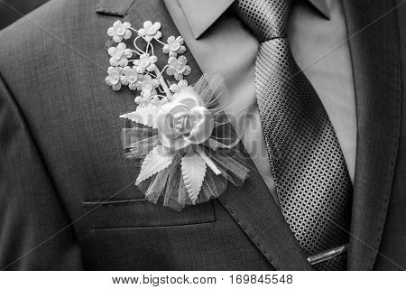 A man in a suit with a bow pinned to the chest wedding