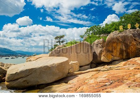 Landscapes on Hon Do island in the sea near Nha Trang city, Vietnam. Clouds, sky and orange rocks. Vibrant horizontal image