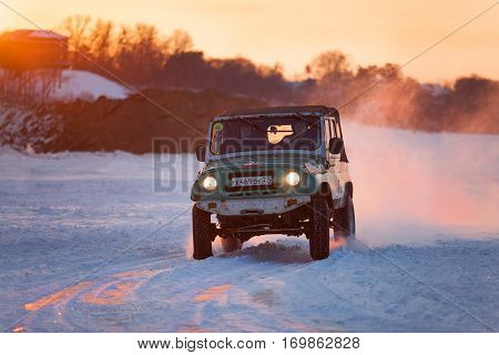 KHABAROVSK RUSSIA - JANUARY 28 2017: Russian UAZ 469 moving on ice of a frosn river at sunset