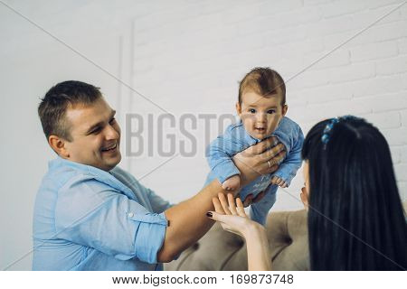 happy family consisting of mom and dad's baby boy. happy family relationships. father holding the baby in his arms. child flies