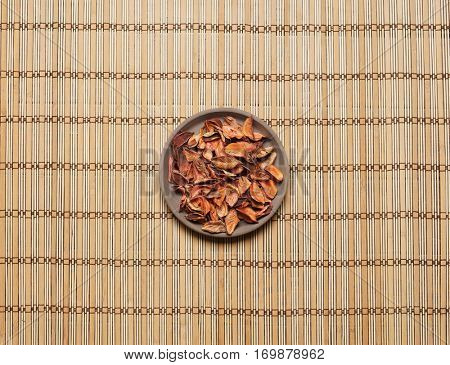 Plate with aroma petals on bamboo mat. Spa, beauty, treatment concept. 