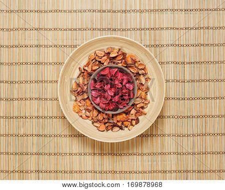 Plate with aroma petals on bamboo mat. Spa, beauty, treatment concept. 