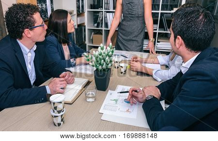 Teamwork looking to unrecognizable businesswoman in a meeting around of table in company headquarters