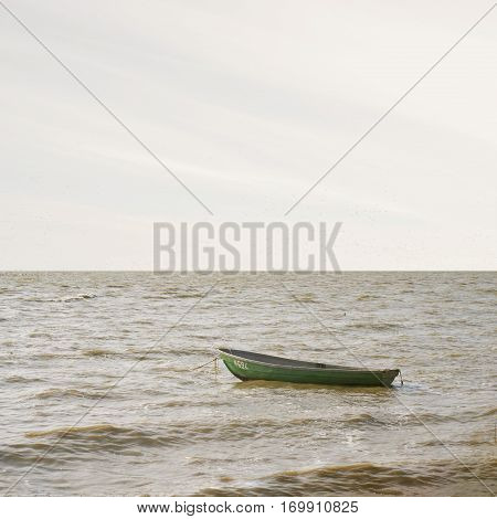 abandoned boat floating on a laggon, overcast weather