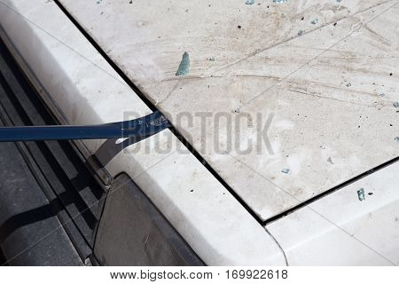 forensic hand in glove lift car bonnet by crowbar to search evidence from car bomb in crime scene investigation training