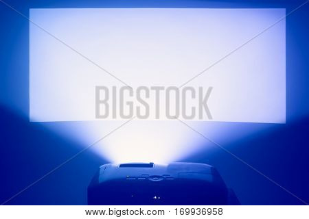 projector in action with illuminated warm blue screen