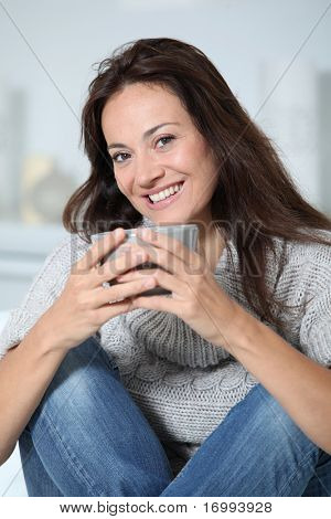 Closeup of beautiful woman with hot drink at home