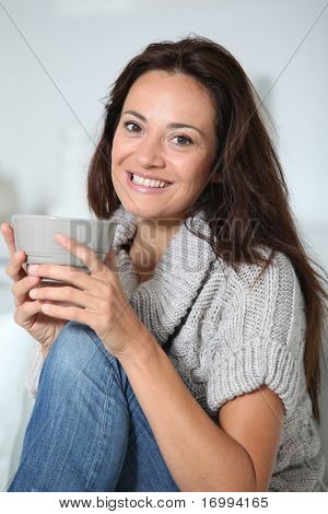 Closeup of beautiful woman with hot drink at home