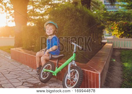 Active Blond Kid Boy Driving Bicycle In The Park Near The Sea. Toddler Child Dreaming And Having Fun