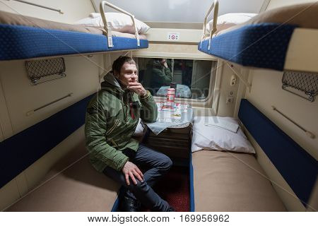 A Passenger Of A Young Man Sitting In A Train Compartment