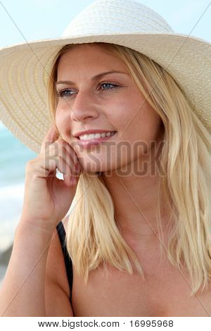Closeup ของผู้หญิงผมสีทองสวยงามสวมใส่หมวกที่ชายหาด