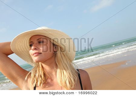 Closeup ของผู้หญิงผมสีทองสวยงามสวมใส่หมวกที่ชายหาด