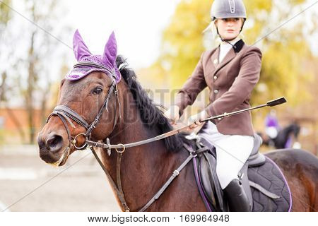 Young jockey girl riding horse on equestrian sport competition