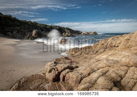 Waves Crash Onto A Small Sandy Cove Near Calvi In Corsica