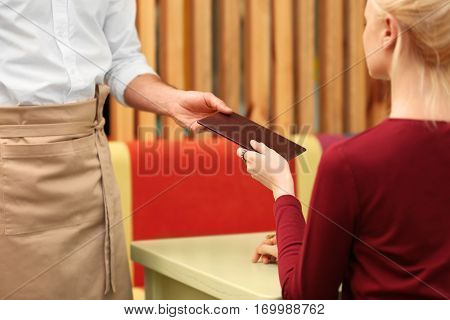 Client getting bill from waiter at restaurant, closeup