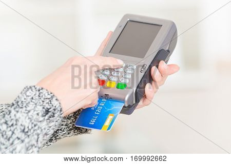 Entering PIN code on wireless payment terminal with inserted redit or debit card