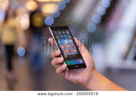 Chiang Mai, Thailand - Oct. 28,2018: Man Holding Huawei With Icons Of E-commerce And Online Shopping