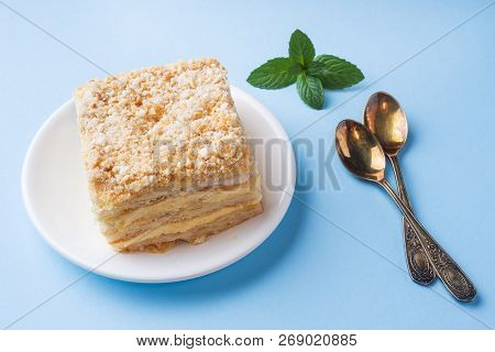 Layer Cake With Cream Napoleon Millefeuille Vanilla Slice With Mint On A Colored Blue Background.