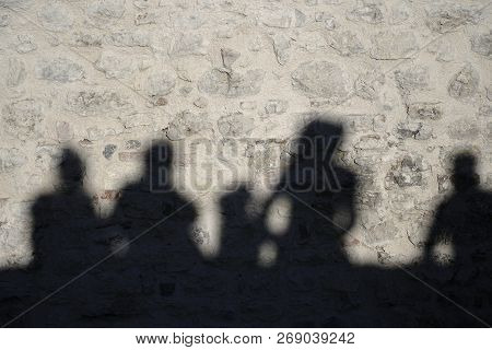 Shadows Of People On The Stone Wall
