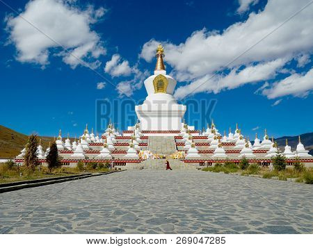 A Monk Walking Around Namgyal Tallinn Pagoda In Daocheng, Sichuan, China