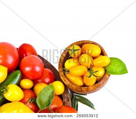 Assorted tomatoes and vegetables isolated on white background. Photo for your design
