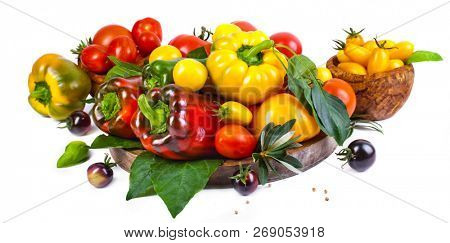 Assorted tomatoes and vegetables isolated on white background. Photo for your design