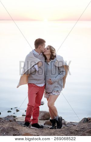 Family Wrapped Up In A Plaid Walking At The Sunset