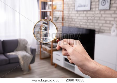 Close-up Of A Man Holding Magnifying Glass