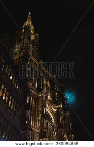 Low-angle View Of Notre-dame Cathedral And Maison Kammerzell Decorated With Christmas Lights And Ful