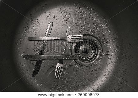 Forks With Knifes As Hashtag Sign In Kitchen Sink. Close-up Of Stainless Steel Sink With Tableware, 