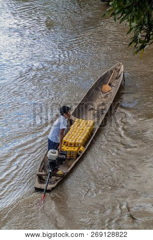 Napo, Peru - July 15, 2015: Villager Transports Beer Cans In A Canoe On A River Napo, Peru