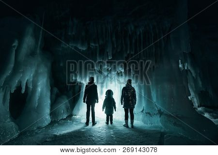 Surreal Landscape With People Exploring Mysterious Ice Grotto Cave. Outdoor Adventure. Family Explor
