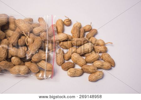 Groundnuts Or Peanuts Coming Out Of The Plastic Bag On Isolated Background