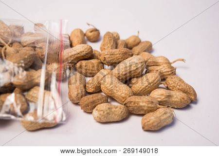 Groundnuts Or Peanuts Coming Out Of The Plastic Bag On Isolated Background