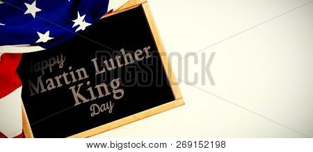 happy Martin Luther King day against american flag and slate on table