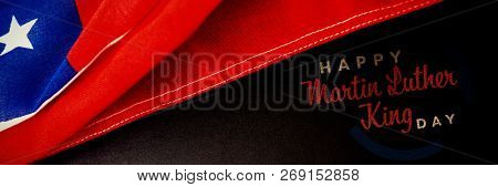 happy Martin Luther King day against national flag and slate on wooden table
