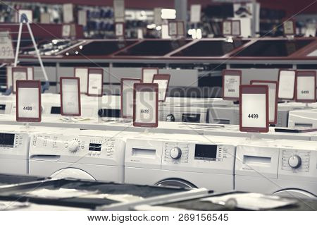 Rows of washing mashines in appliance store showroom, toned version