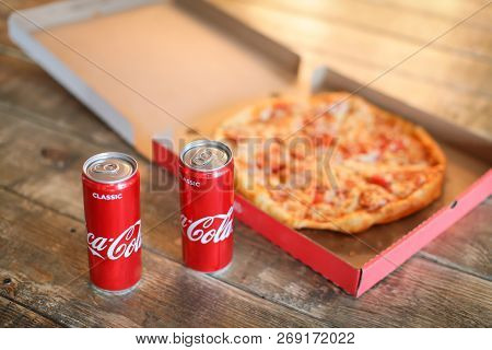 Slice Pizza In Box And Can Of Soda On Wood Background