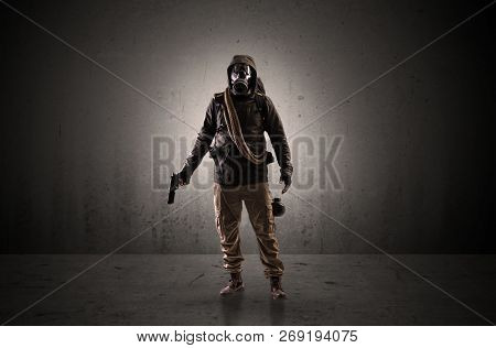 Bad agent in a dark room with arms on his hand and gas mask