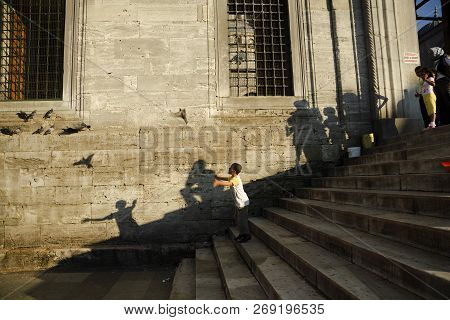 Istanbul, Turkey - September 8, 2010: A Boy Caught A Pigeon And Released It. Other People Were Watch