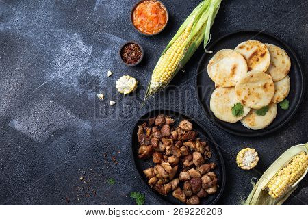 Colombian Food. Maize Arepas And Fried Pork Chicharron Ans Colombian Tomato Sauce. Top View. Black B