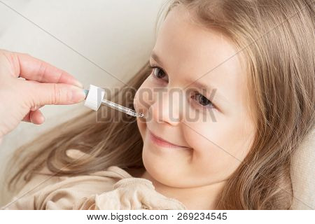 Runny Nose In Children. Mom Is Dripping In The Nose Girl Drops.